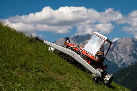 Reform Metrac bei der Arbeit mit einem Stöckl Doppelmessermähwerk und Stöckl Stachelwalzen in Hanglage
