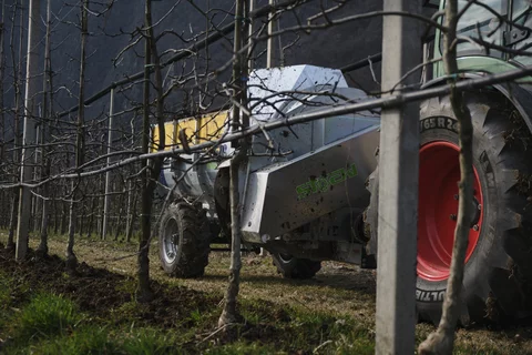 Stöckl trailer-mounted side spreader in use on an apple orchard