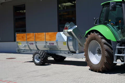 Stöckl trailed side spreader towed by a Deutz Fahr tractor