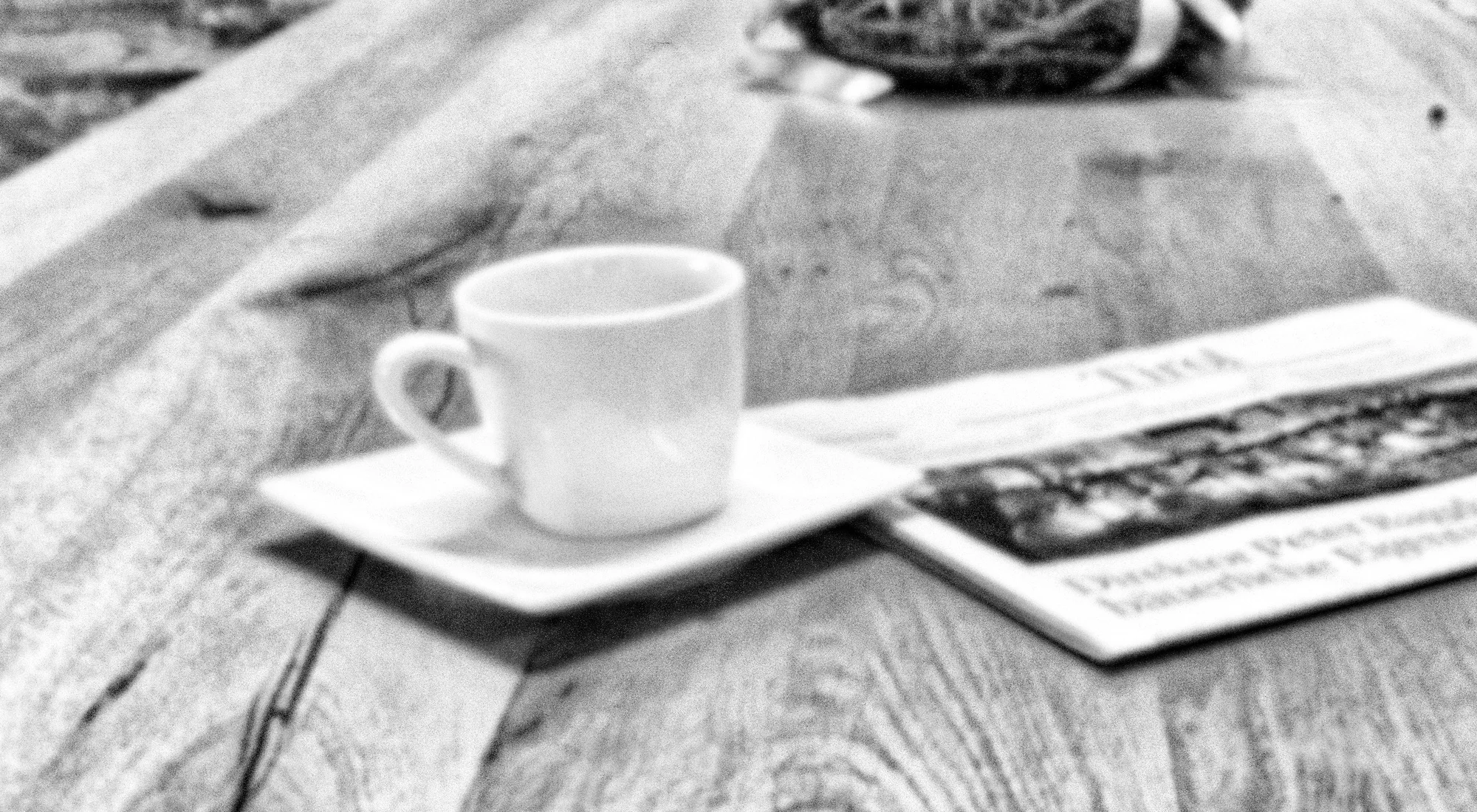 Schwarzweiß Abbildung einer Kaffeetasse mit Zeitung